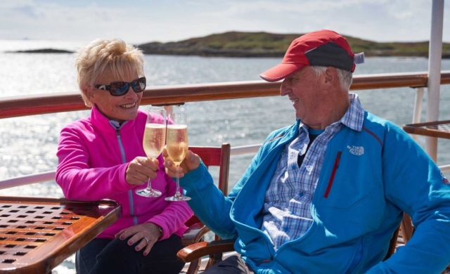 A couple enjoying some champagne on the Promenade Deck on the Hebridean Princess cruise ship of Hebridean Island Cruises