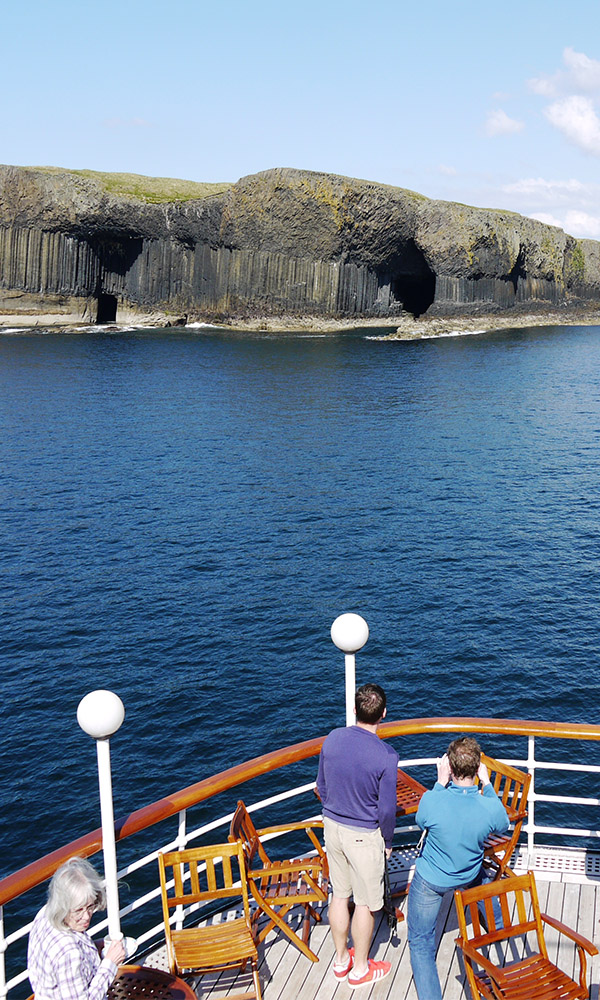 Fingals Cave with guests taking in the view from the Boat Deck on the Hebridean Princess cruise ship of Hebridean Island Cruises