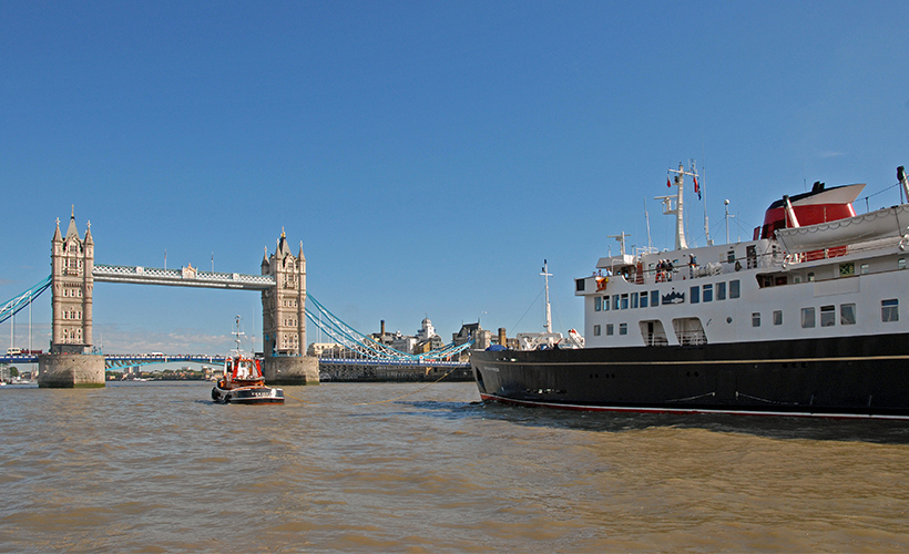The Hebridean Princess cruise ship sailing up the River Thames with London Bridge in the background