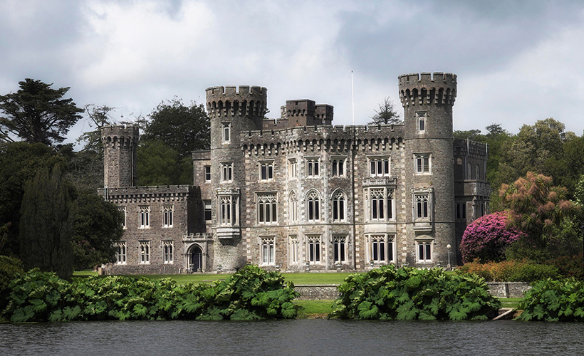 The stunning exterior of Johnstown Castle overlooking a lake