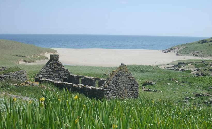 The ruin of a croft by a sandy bay on the island of Mingulay in Scotland