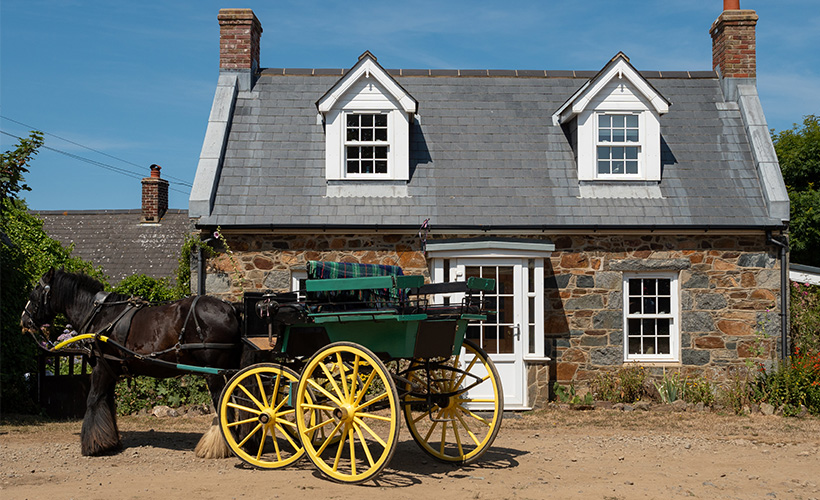 A horse and cart outside a quaint cottage on Sark